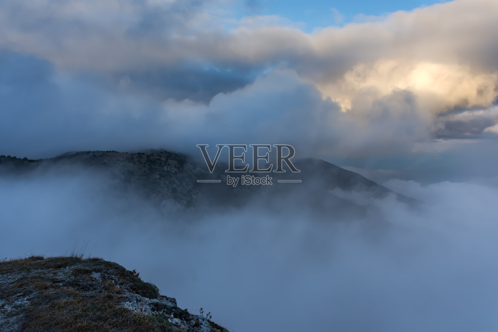 大气景观与巨大的云在山上。壮观的天空笼罩着群山。照片摄影图片