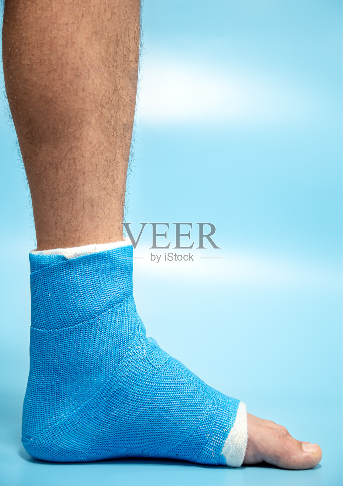 脚部蓝色夹板治疗踝关节扭伤损伤的近距离照片。照片摄影图片