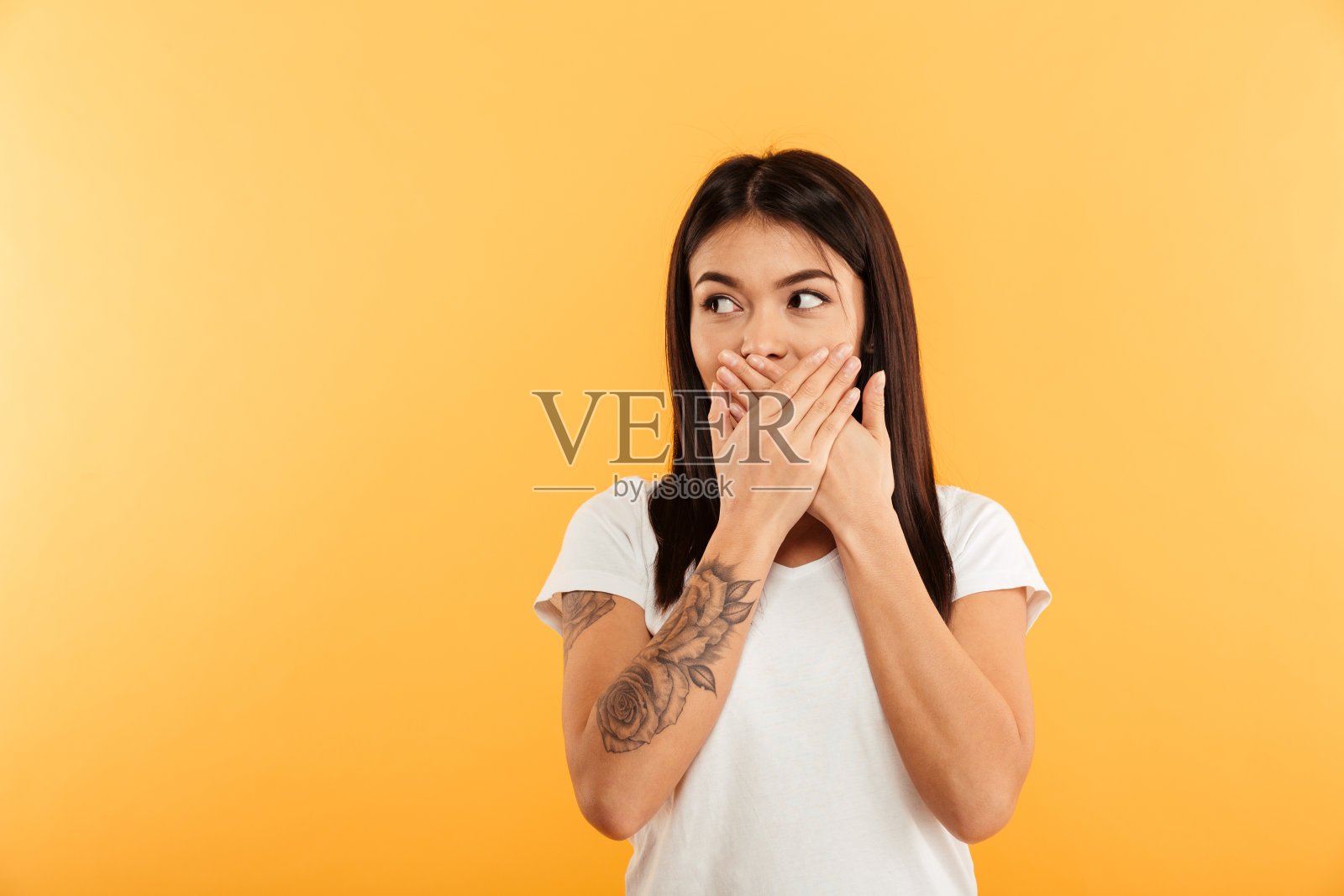 年轻漂亮的女人用手捂着嘴。照片摄影图片