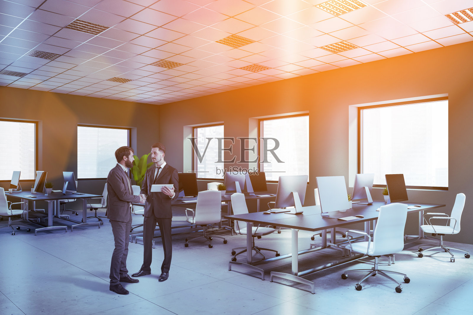 两个商人在灰色的开放式办公室里照片摄影图片