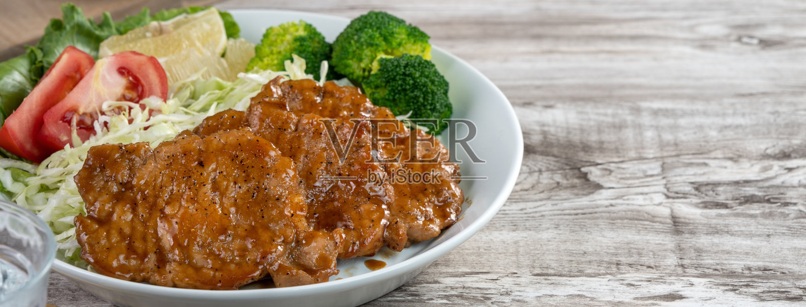 美味多汁的猪排配蔬菜和水果沙拉。照片摄影图片