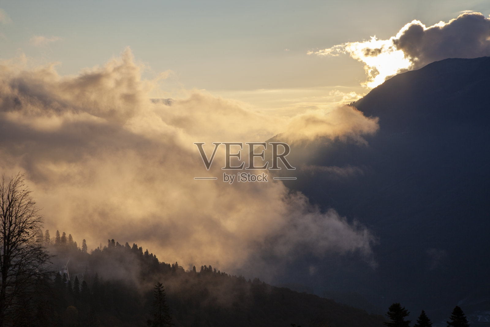 红杉波利亚纳，索契，北高加索的山脉，白雪皑皑的山峰映衬着秋天的树木，夕阳越过山脉和云彩照片摄影图片