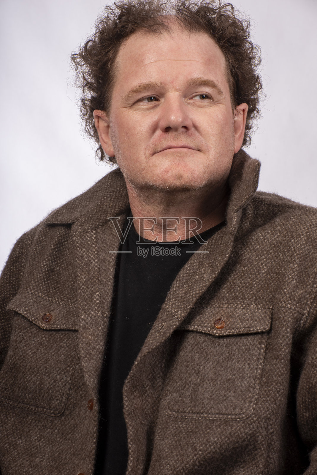 一位中年男子穿着一件牦牛皮大衣御寒。照片摄影图片