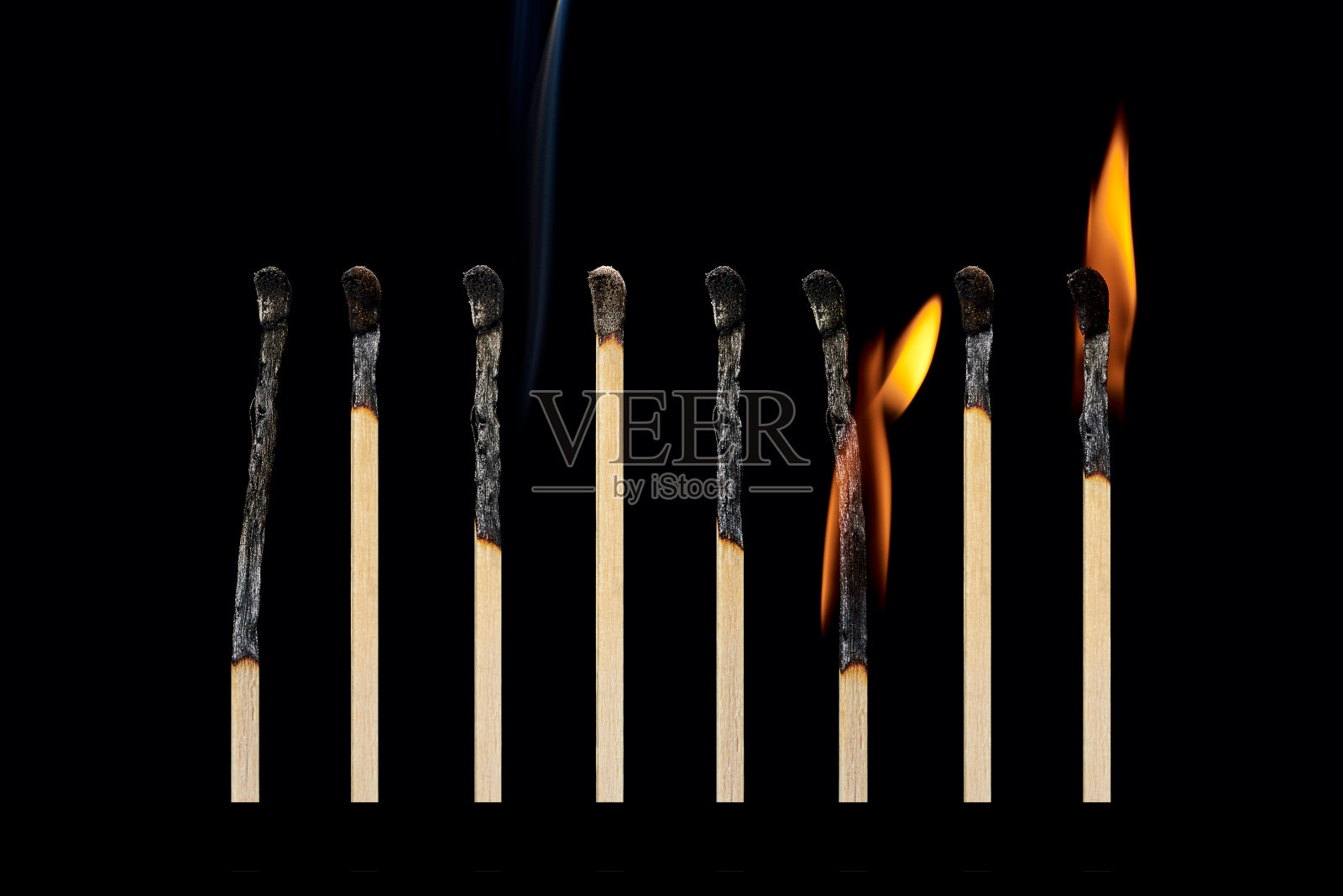 一组不同的燃烧过的火柴，有烟，有不同的火，孤立在黑色的背景上。照片摄影图片