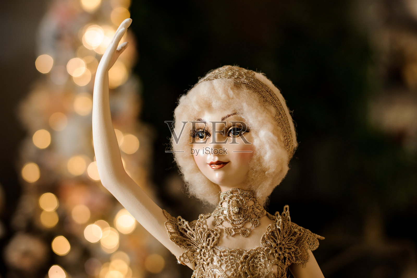 特写上美丽的娃娃在金色的衣服与举起的手照片摄影图片