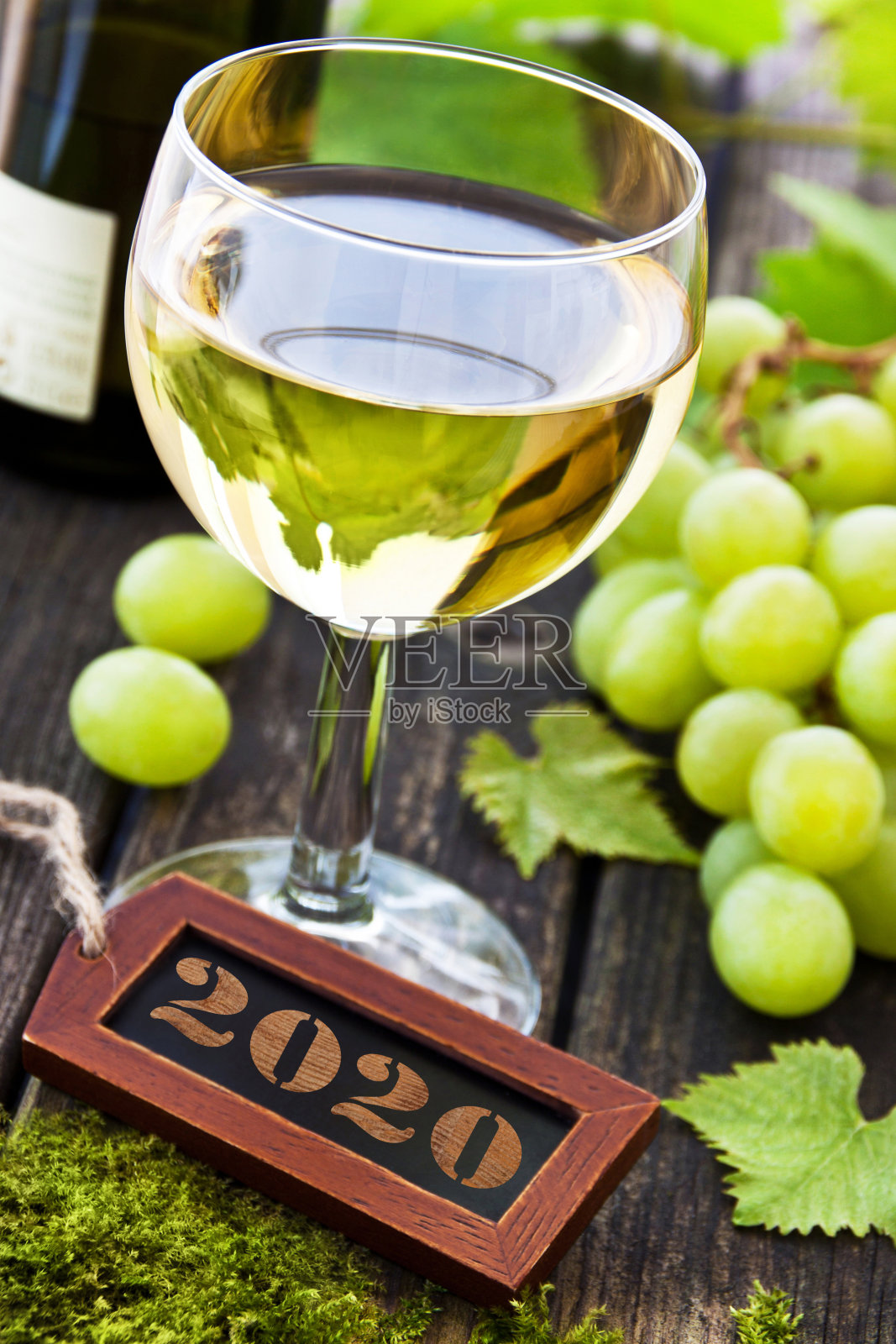 木桌上的白葡萄酒，标签是2020照片摄影图片