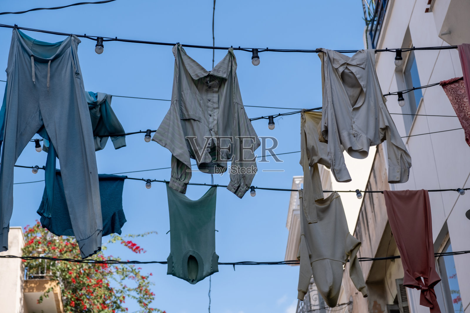 街道上的电线上晾着衣服，背景是蓝天照片摄影图片