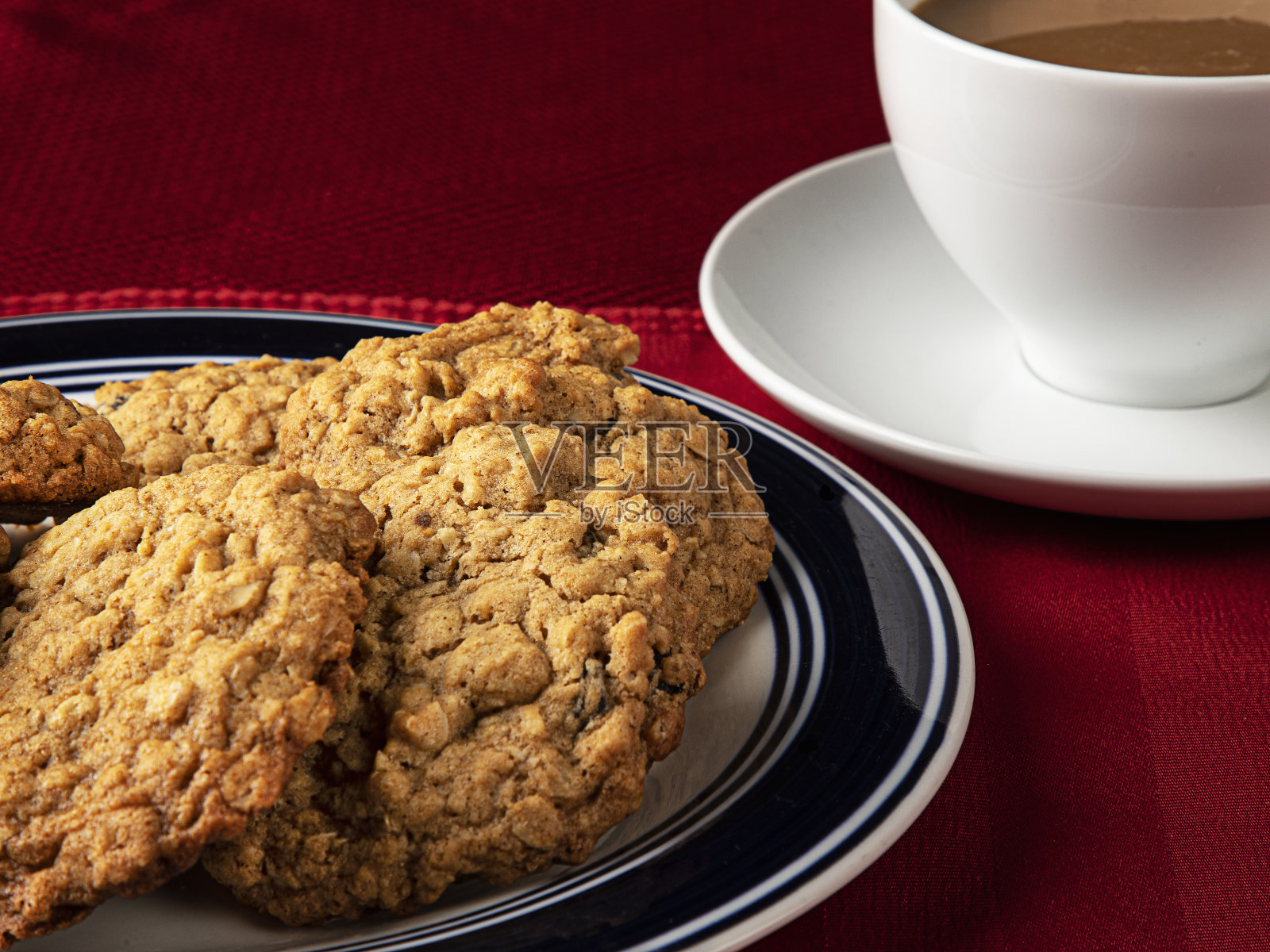 红桌子上有葡萄干燕麦饼干和咖啡照片摄影图片