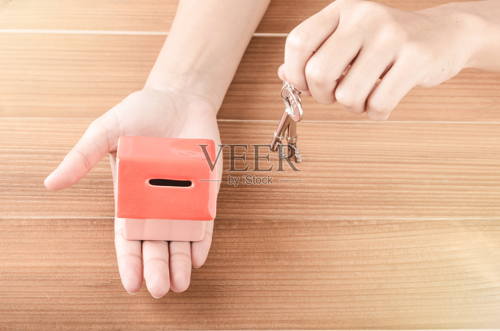 女士手用香家的钥匙放在木背景上照片摄影图片