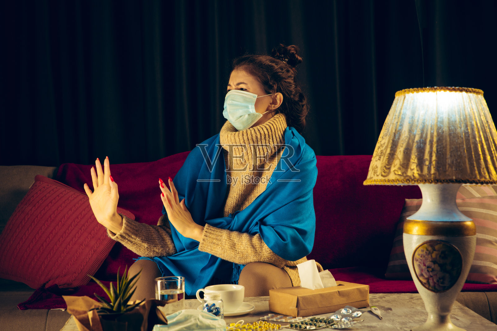 一个裹着格子布的女人戴着面具试图保护别人不生病照片摄影图片