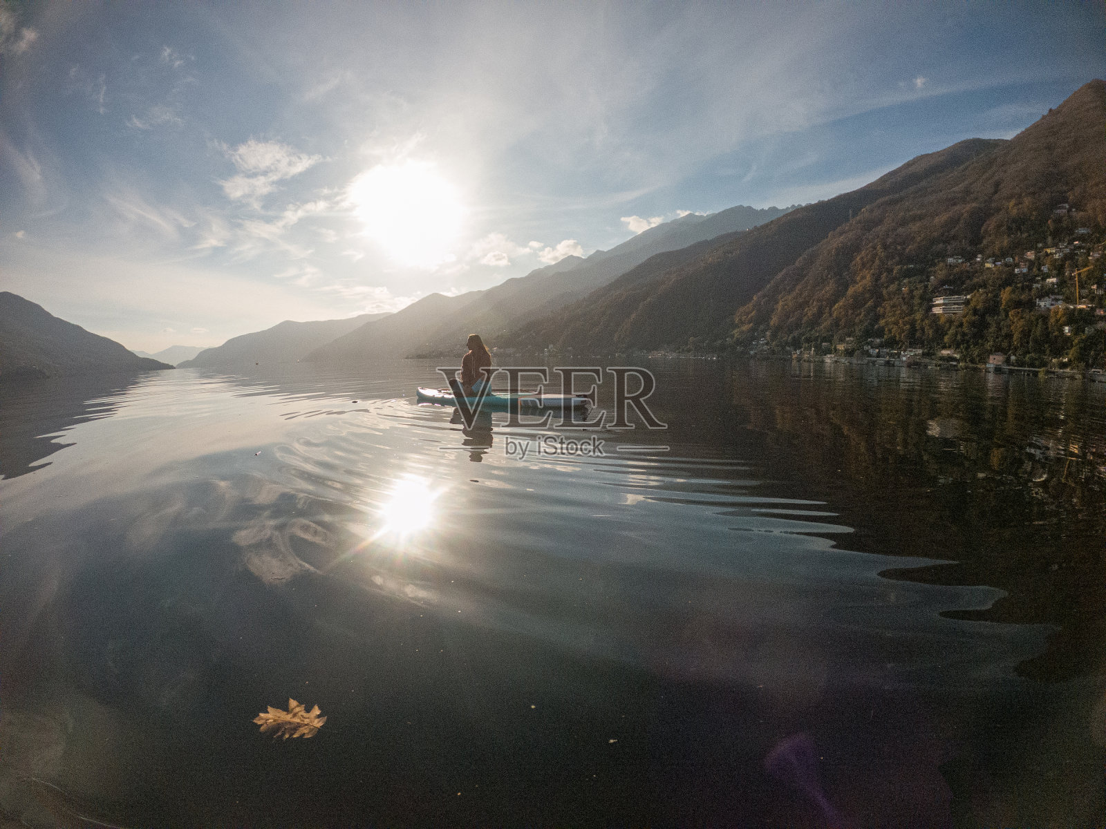 年轻女子在湖上用桨板划水照片摄影图片