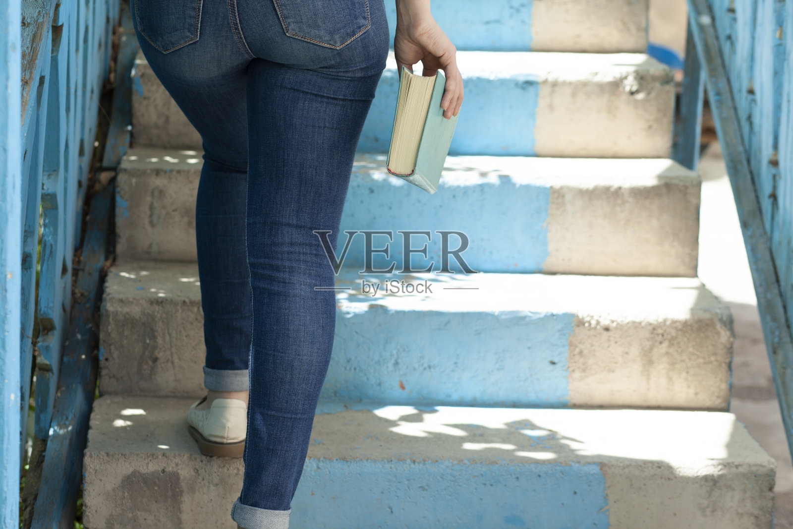 那位妇女在楼梯上拿着书照片摄影图片