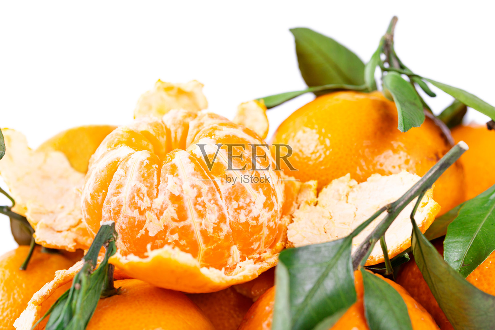 有很多绿叶子的橘子。一个水果去皮照片摄影图片