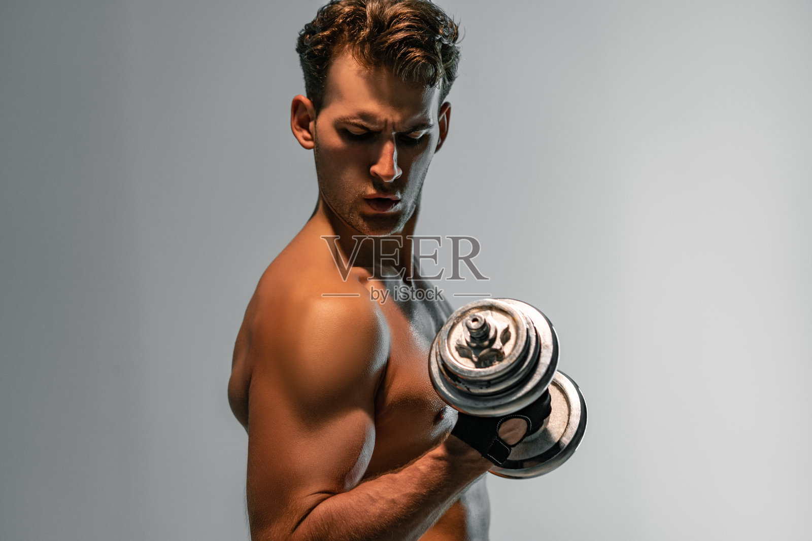 那个年轻的运动员用哑铃训练照片摄影图片