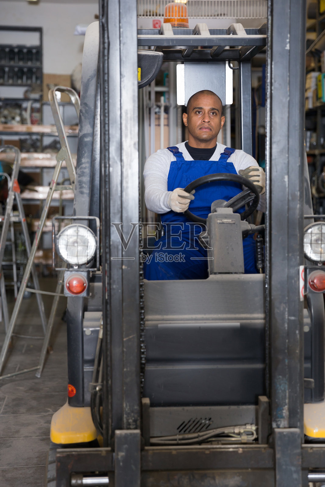 在大型建筑卖场工作的拉丁美洲叉车操作员照片摄影图片