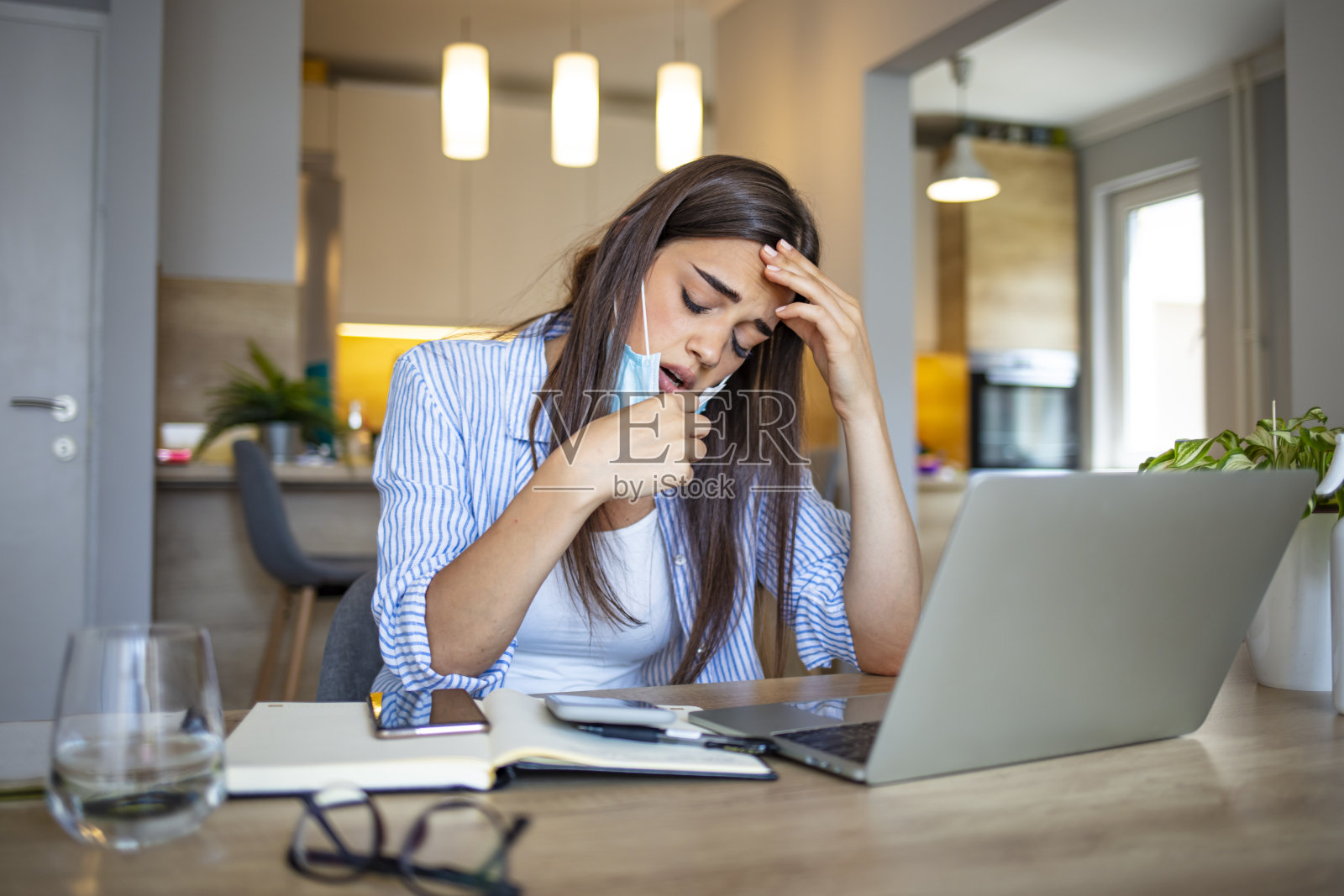 摘掉面具后拿着面具的女人。照片摄影图片