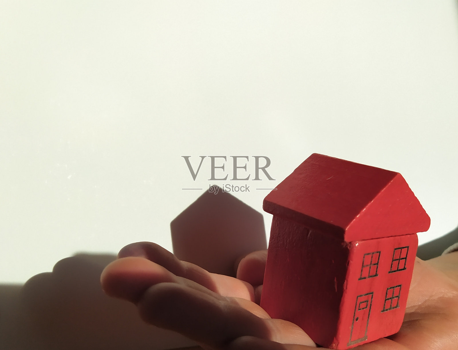 一手拿着木屋。照片摄影图片