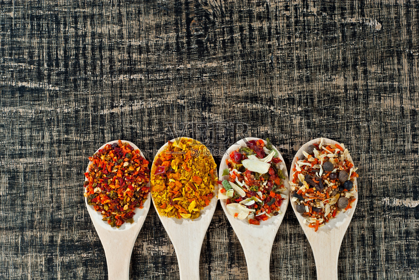 用木勺混合各种香料香料和调味料放在破旧的木板上。凑成一堆。放置文本和复制空间附近的勺子。照片摄影图片