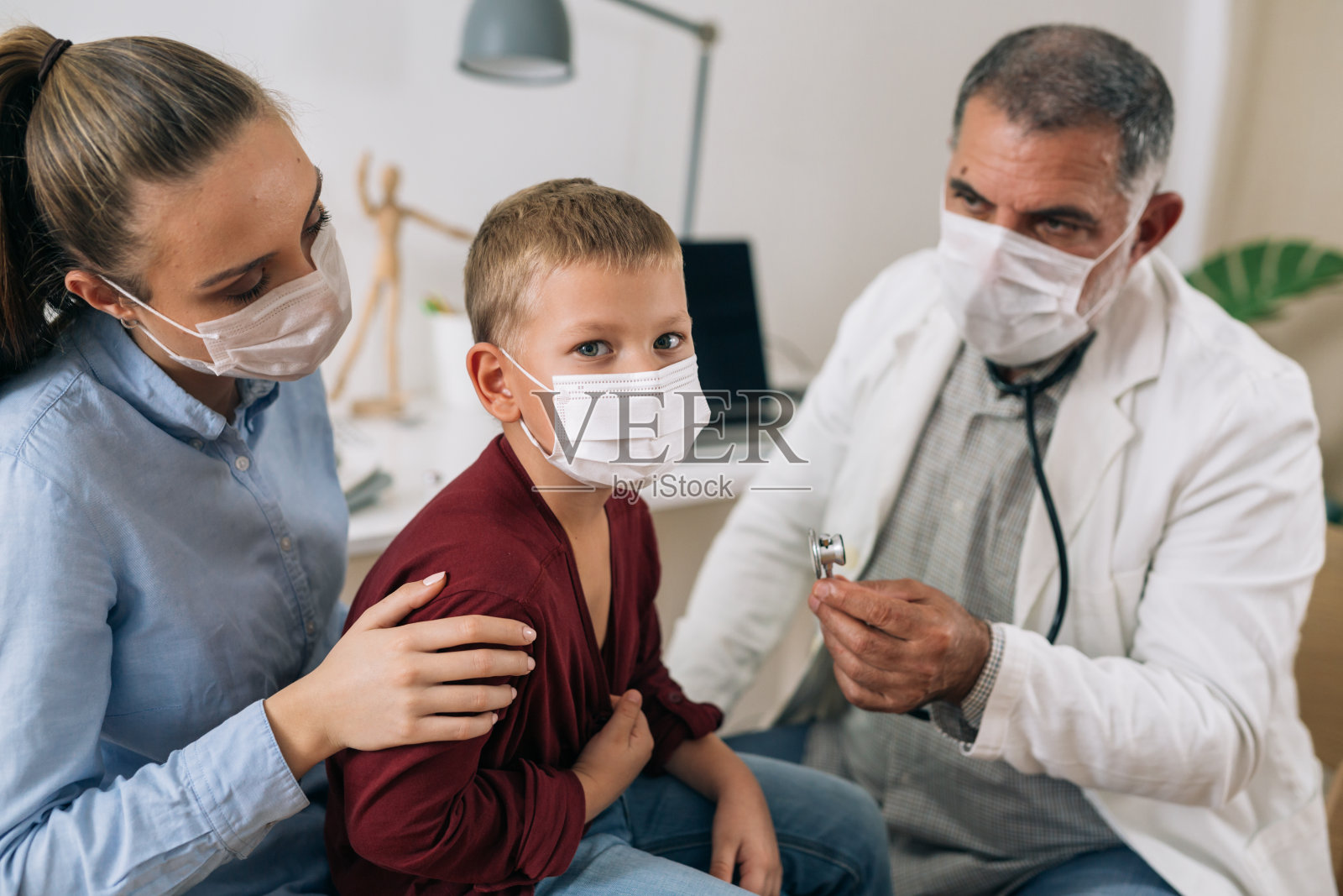 男孩和他妈妈在儿科医生那里照片摄影图片