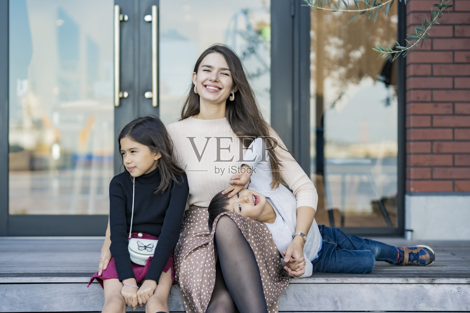 妈妈和两个孩子在嬉戏照片摄影图片