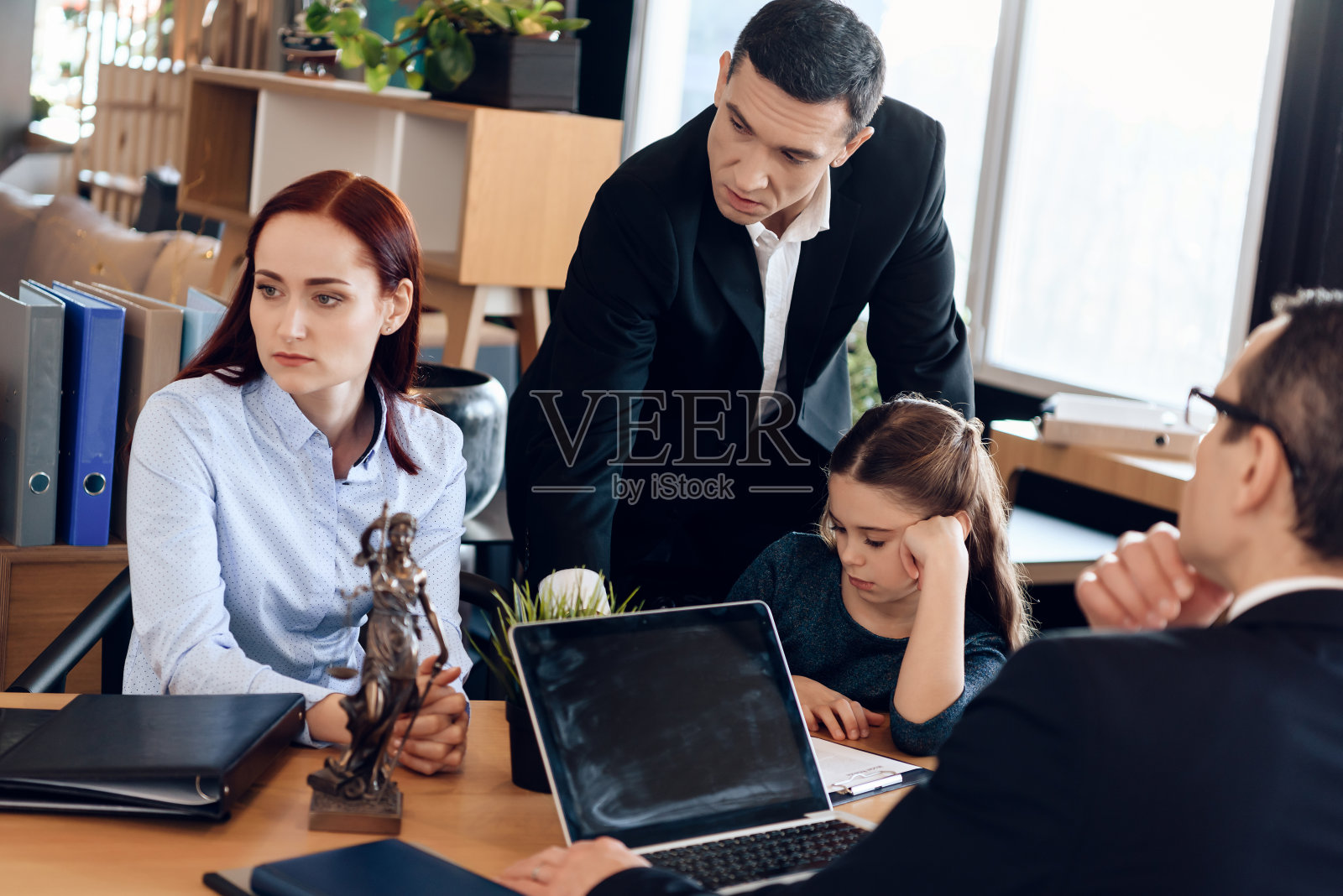 在律师办公室里，父母们为谁来监护小女儿而争论不休。照片摄影图片