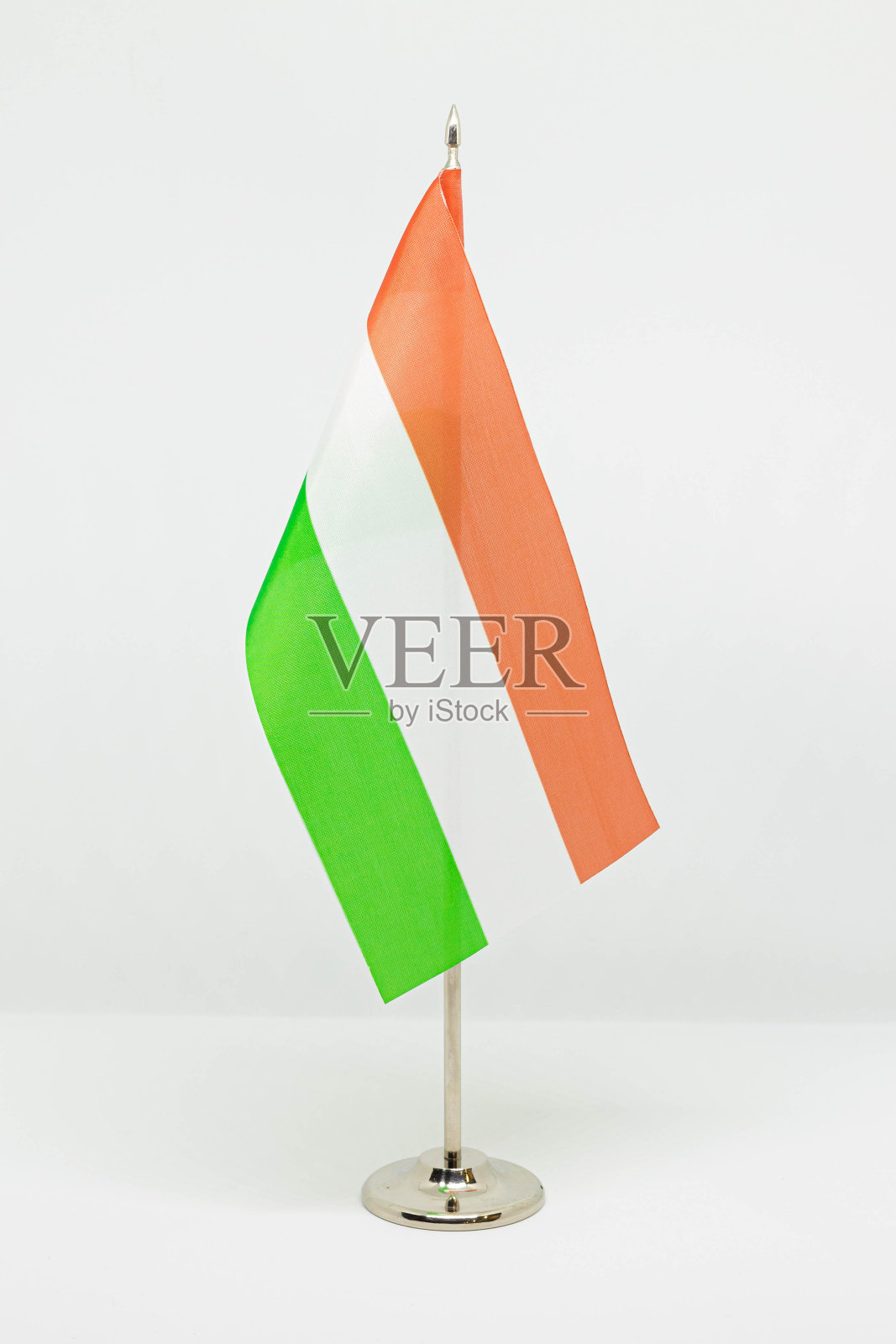 匈牙利国家桌面旗帜上的金属旗杆孤立在白色背景上。照片摄影图片