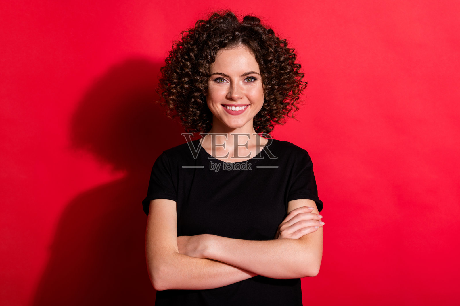 可爱的年轻人微笑双臂交叉的肖像看起来相机孤立在充满活力的红色背景照片摄影图片