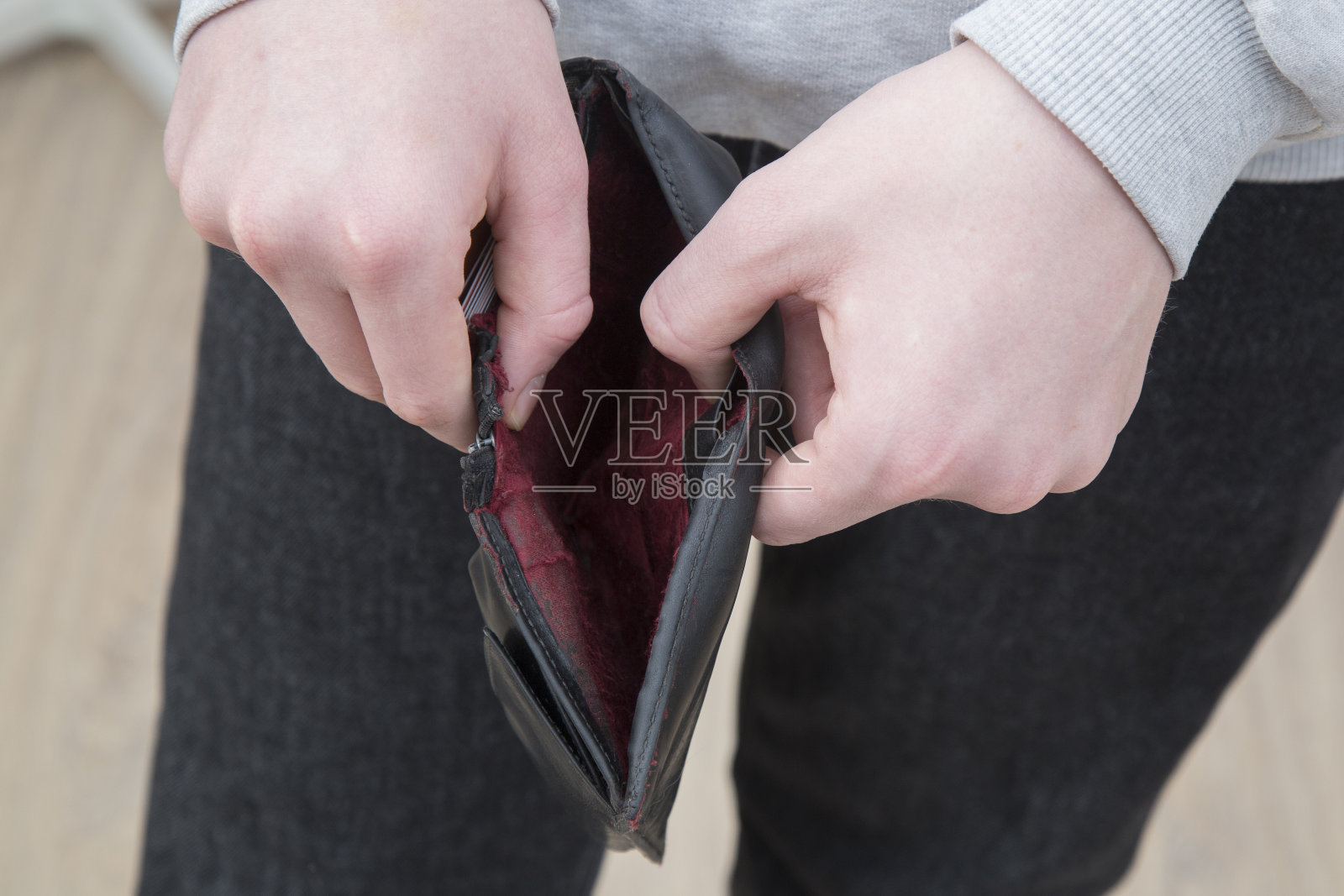 一个人手里没有钱的空钱包。照片摄影图片