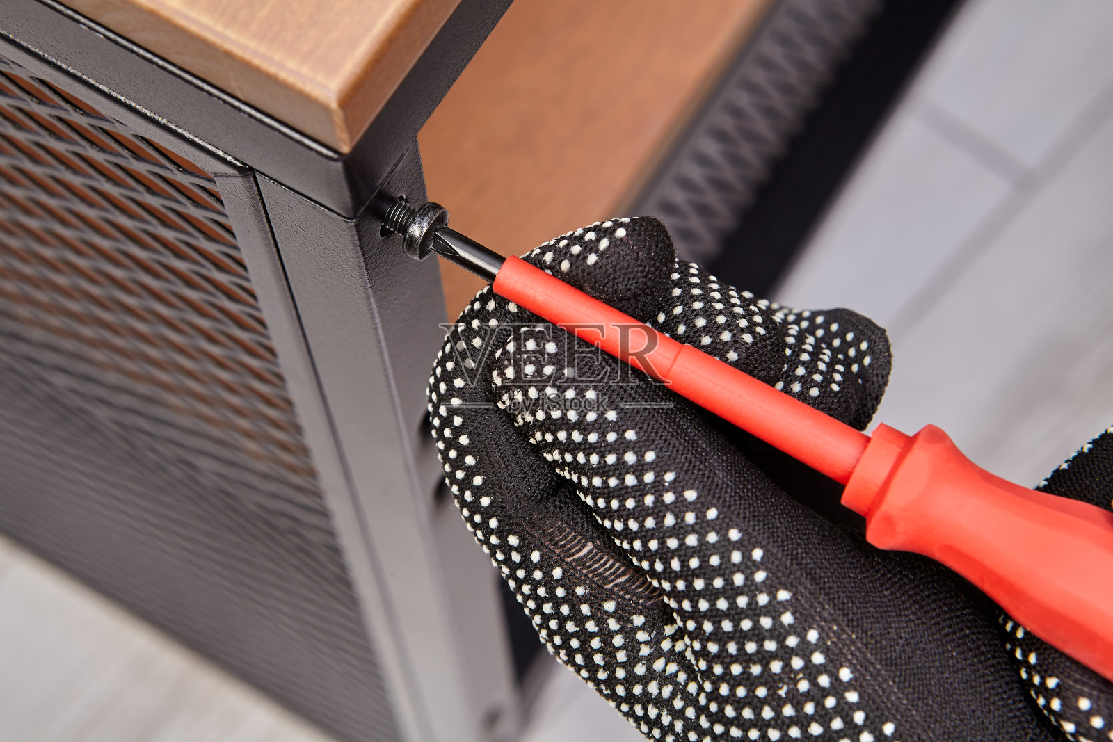 装配工正在安装扁平包装架，同时用螺丝刀拧紧螺栓。照片摄影图片