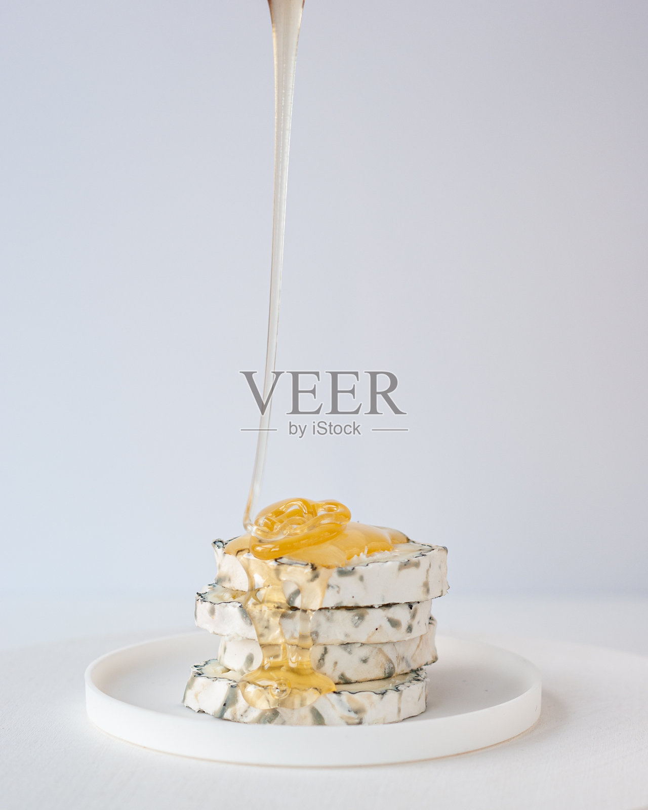 蜂蜜滴在奶酪片上照片摄影图片