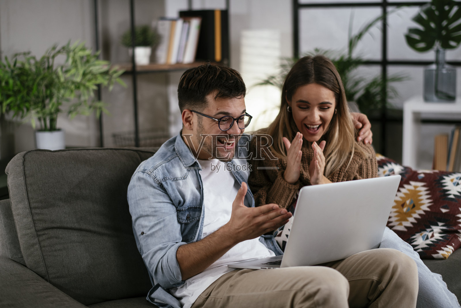幸福的年轻夫妇和笔记本电脑在家里照片摄影图片