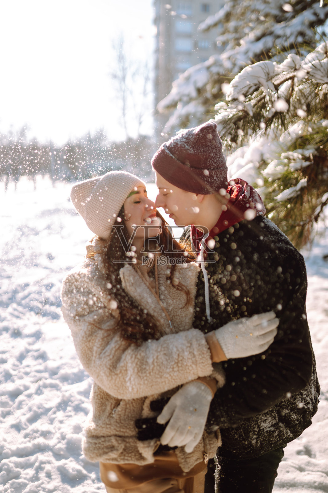 快乐的情侣在冬天的公园里拥抱亲吻。假日、季节、爱与休闲理念。照片摄影图片