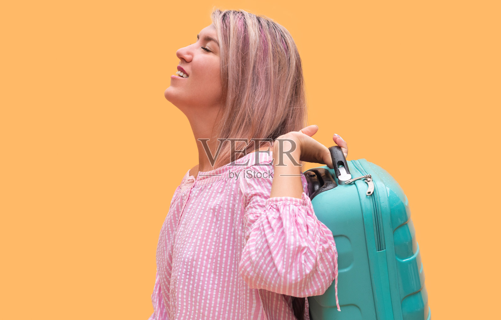 带着绿松石手提箱的女游客照片摄影图片