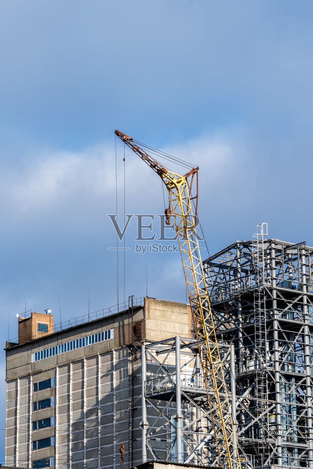 以施工现场为背景吊装施工起重机。照片摄影图片