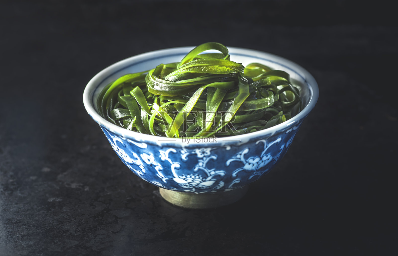 黑色背景上是裙带菜，海菜。健康零食，韩国或日本食品照片摄影图片