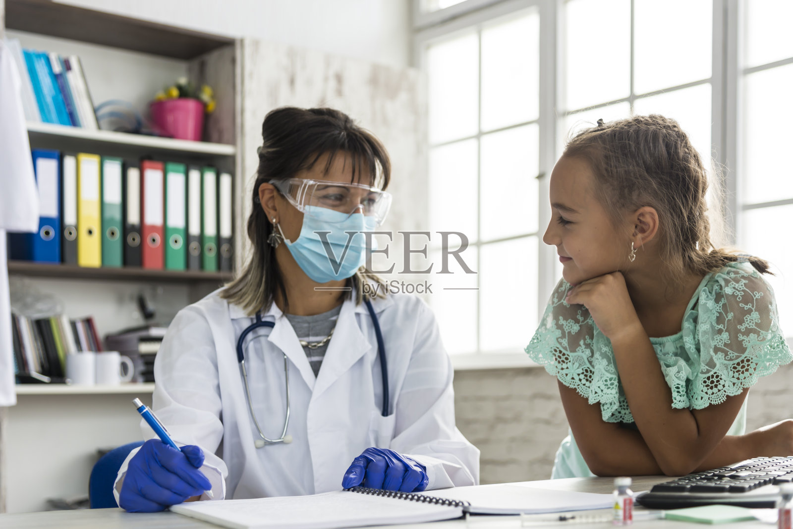 一名儿科医生在COVID - 19大流行期间检查一名儿童照片摄影图片