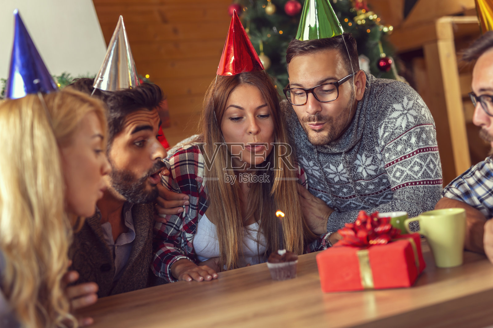 人们吹着生日蛋糕上的蜡烛照片摄影图片