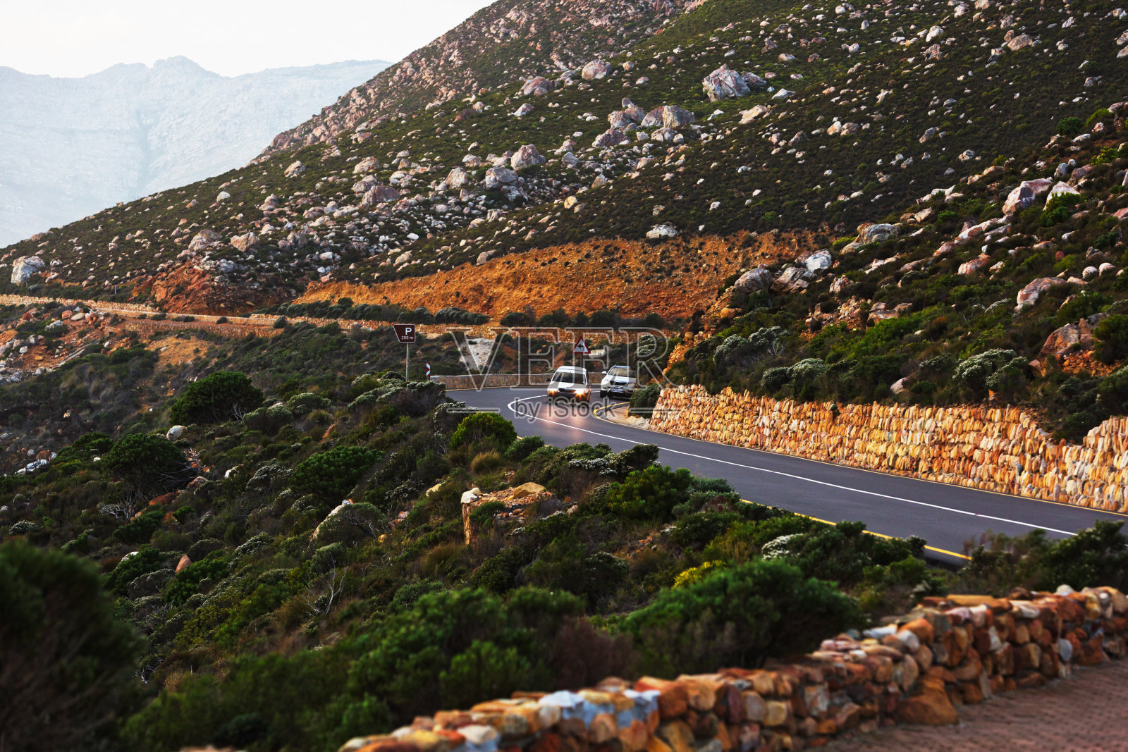 在南非开普敦北部，汽车行驶在戈登湾和克莱恩拜之间崎岖的海岸公路上照片摄影图片