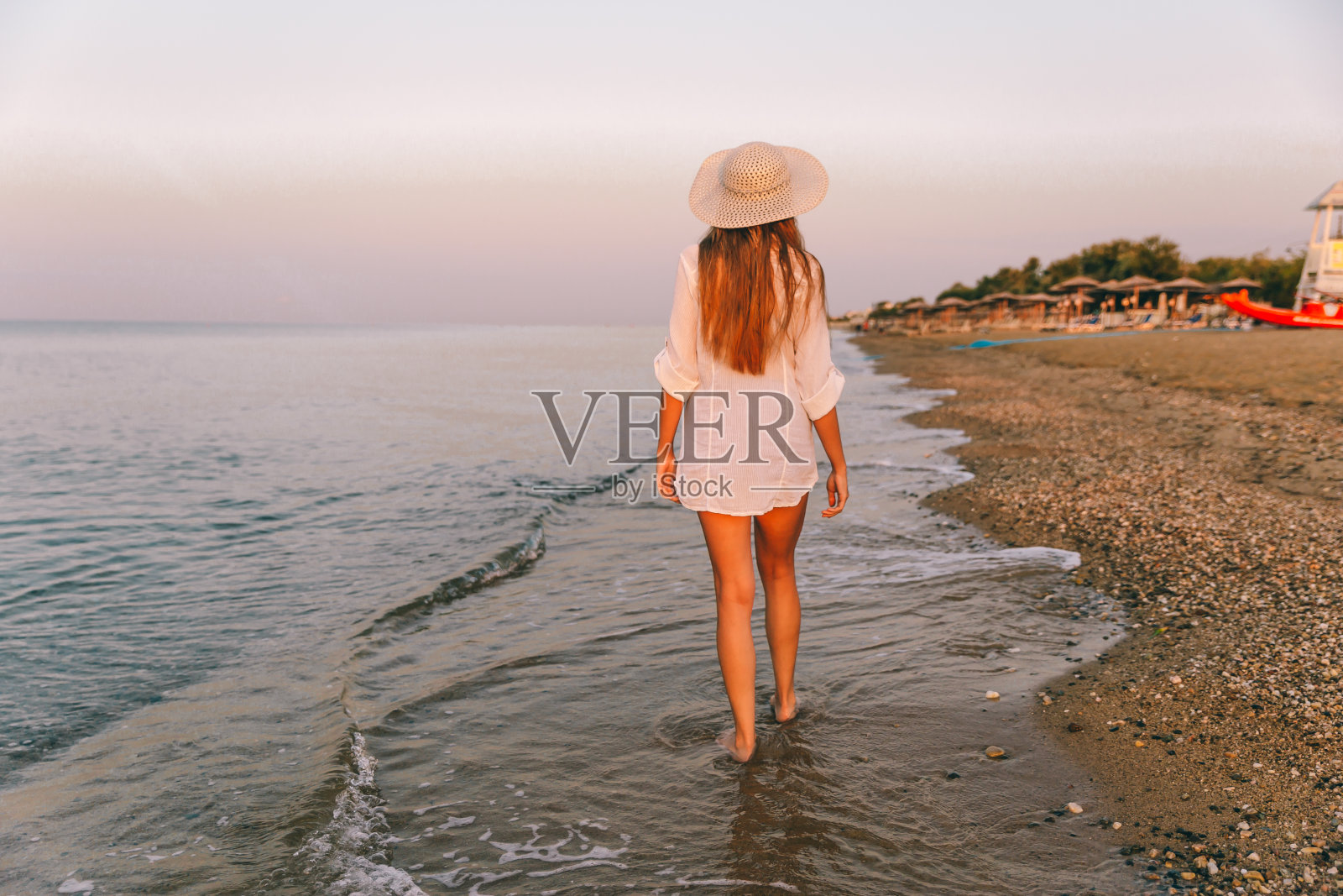 在海滩上散步的女人照片摄影图片