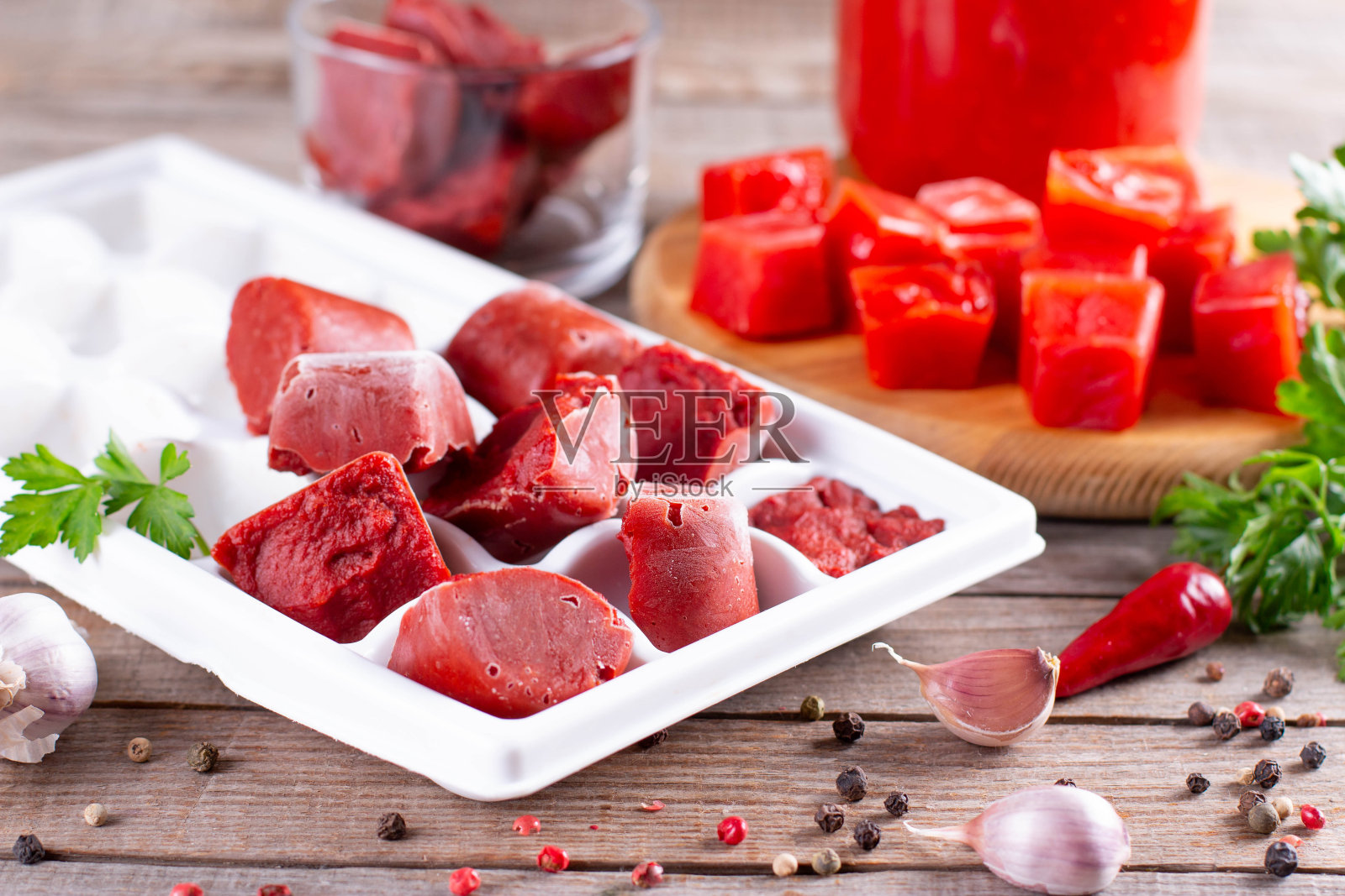 冰冻的番茄酱在木制的背景上的塑料形状。生活小窍门，简单的储存蔬菜的方法照片摄影图片