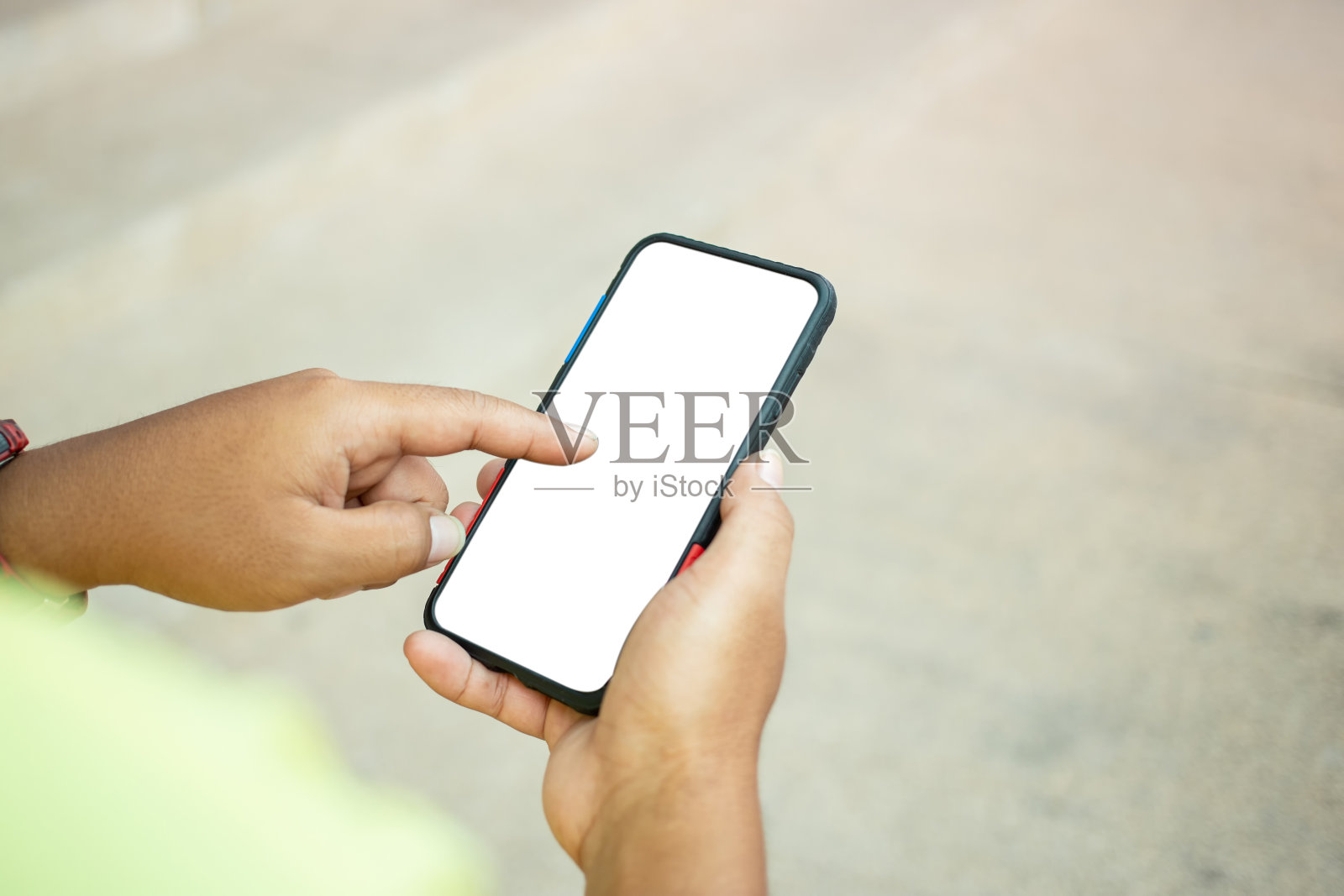 亚洲男人正在白人背景下玩黑色手机的特写。俯视图的亚洲人使用移动智能手机与空白白屏幕。照片摄影图片