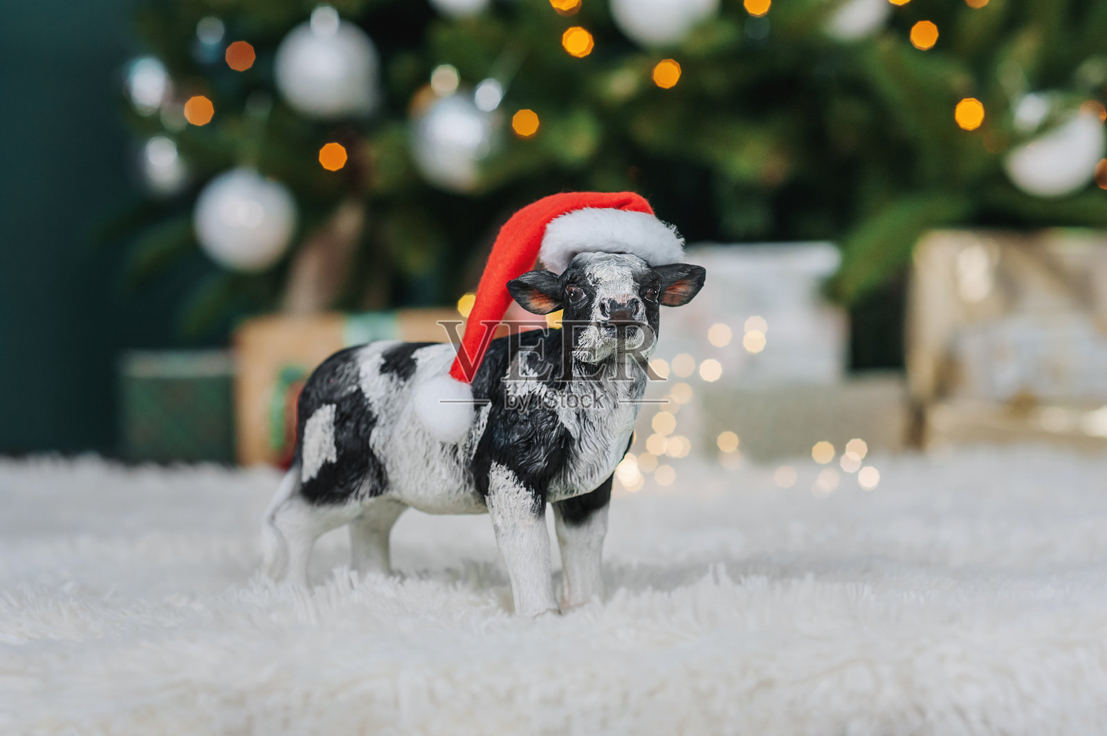 一头奶牛戴着圣诞帽，拉着一个雪橇，上面有圣诞背景上的礼物照片摄影图片