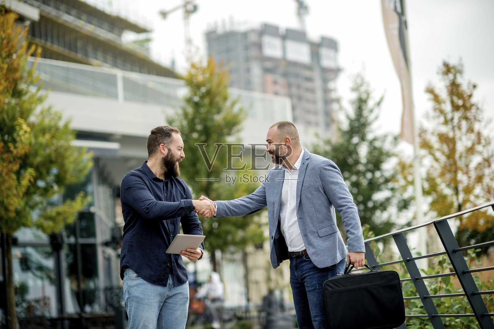 年轻的商业人士拿着平板电脑，讨论公司的未来计划照片摄影图片