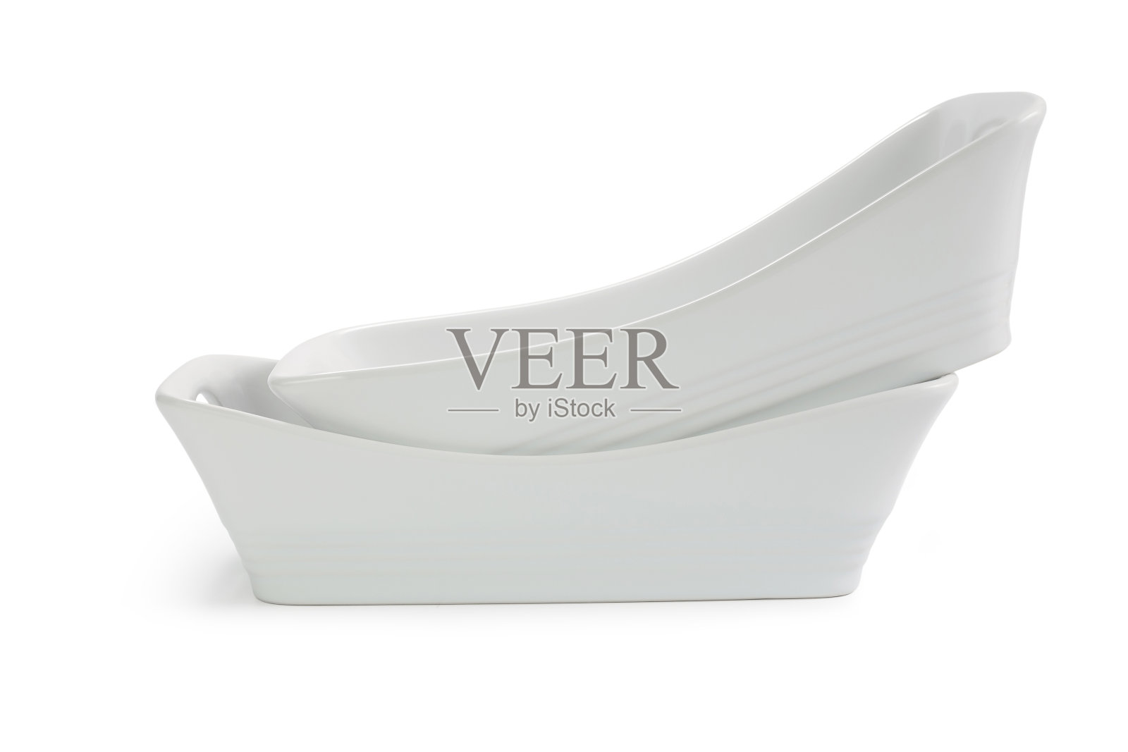 两个白色陶瓷烤盘，一个嵌套在另一个白色背景上照片摄影图片