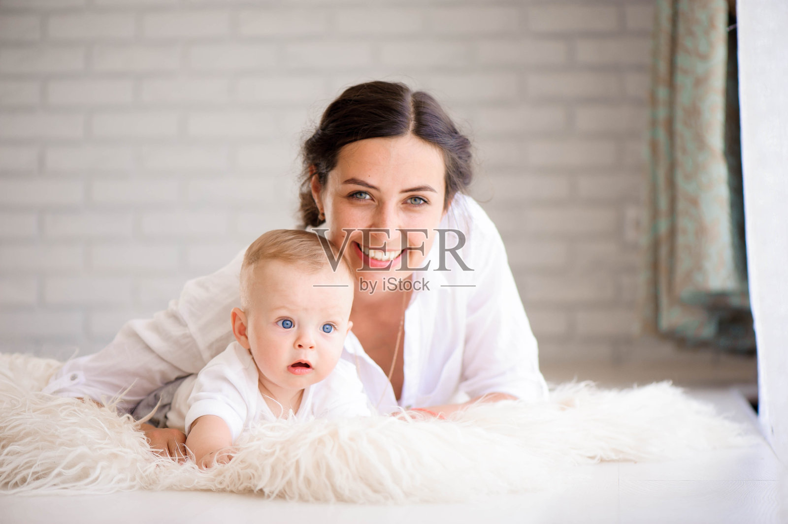 妈妈和男婴穿着尿布在阳光明媚的卧室里玩耍。家庭havi照片摄影图片