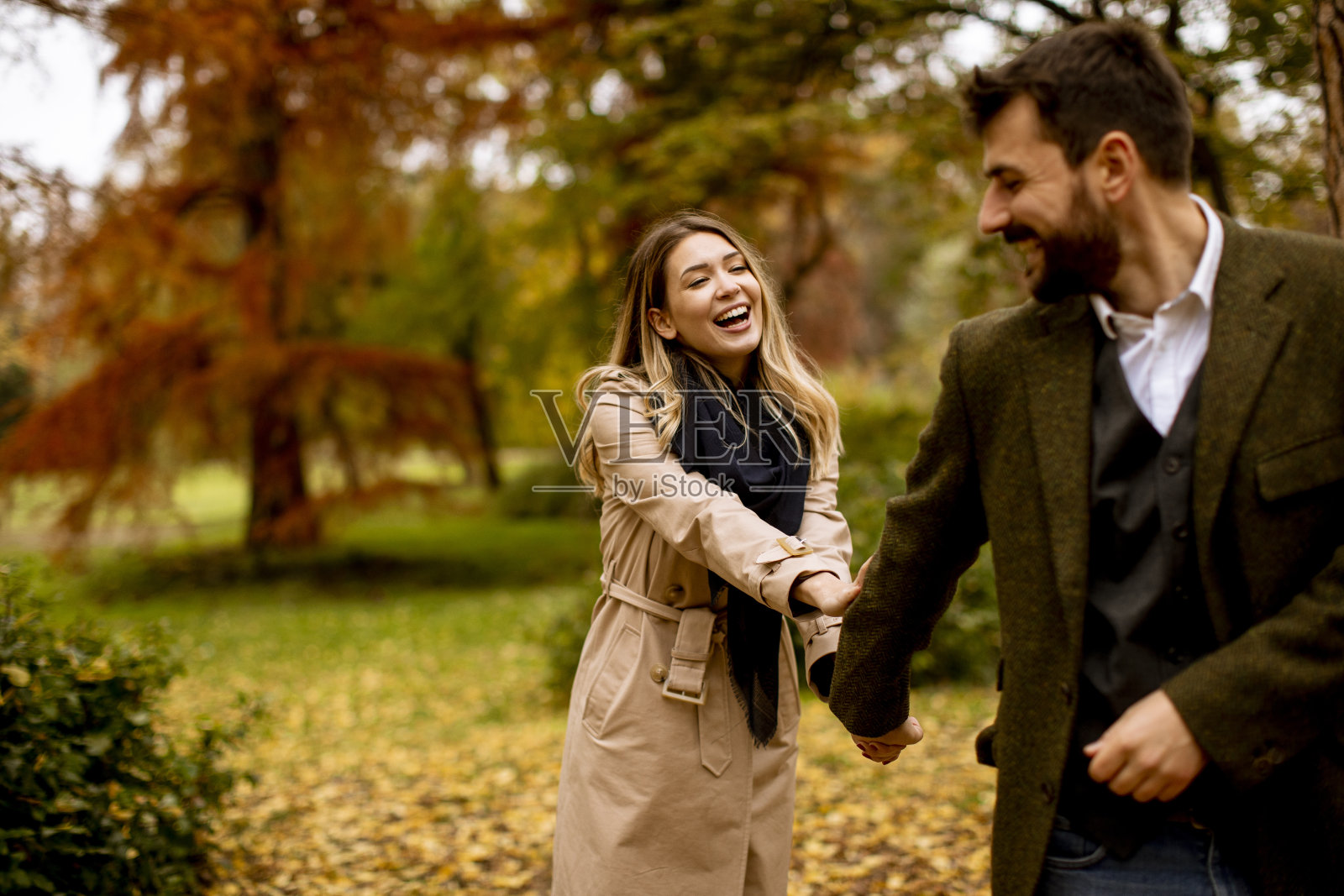 一对年轻夫妇在秋天的公园里散步照片摄影图片