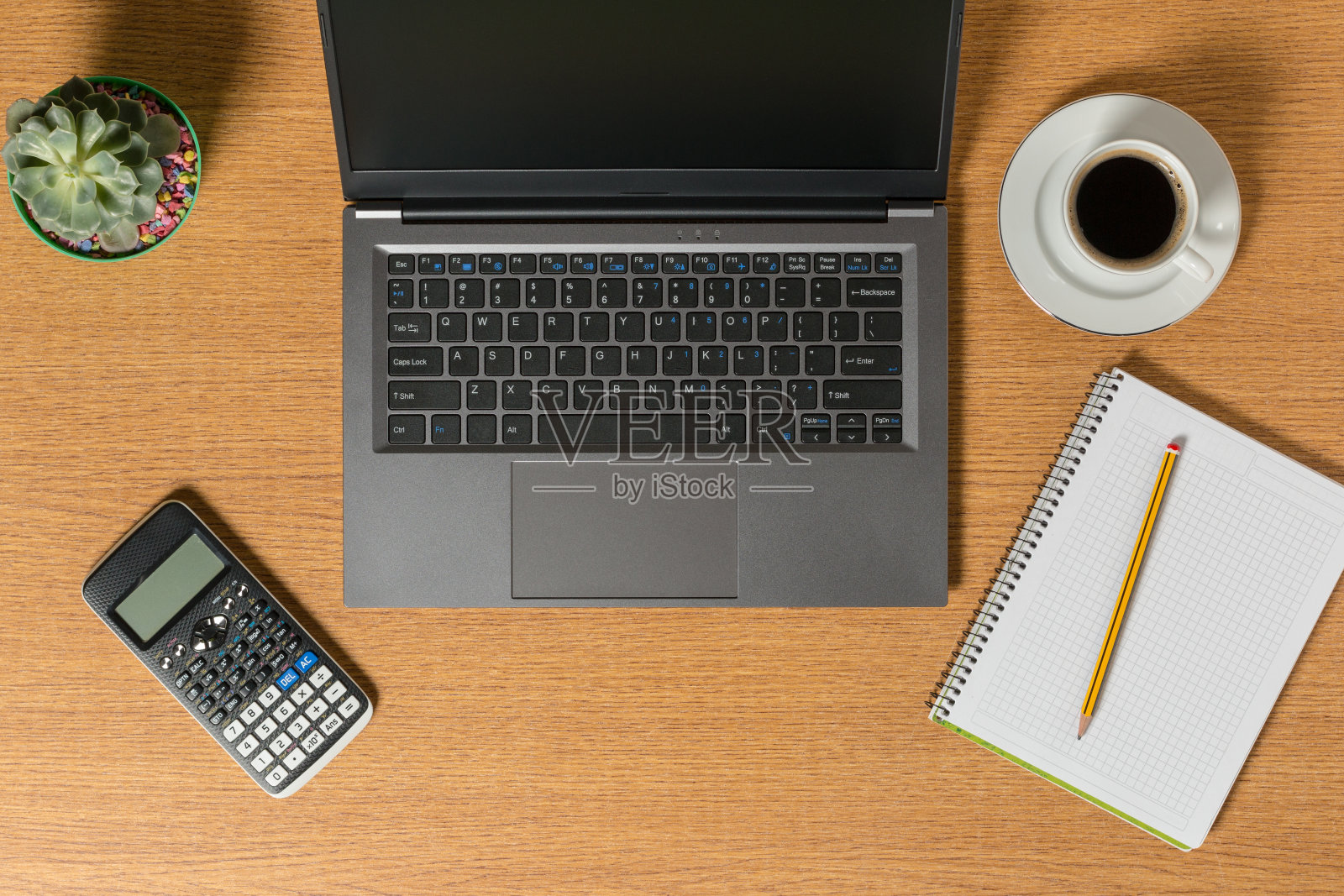 顶视图的工作空间，一个笔记本电脑，一个笔记本，一支铅笔和一杯咖啡。照片摄影图片