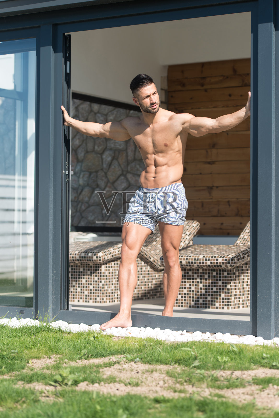 年轻人站在那里，展示肌肉照片摄影图片