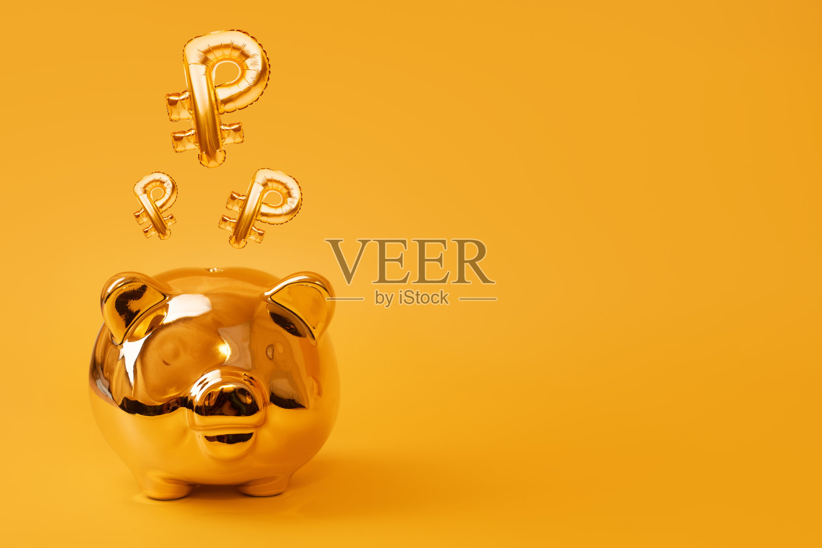 金色储蓄罐黄色背景与金色卢布标志气球。俄罗斯货币符号用铝箔制成的气球。投资和银行概念。储蓄，储蓄罐，金融，投资照片摄影图片