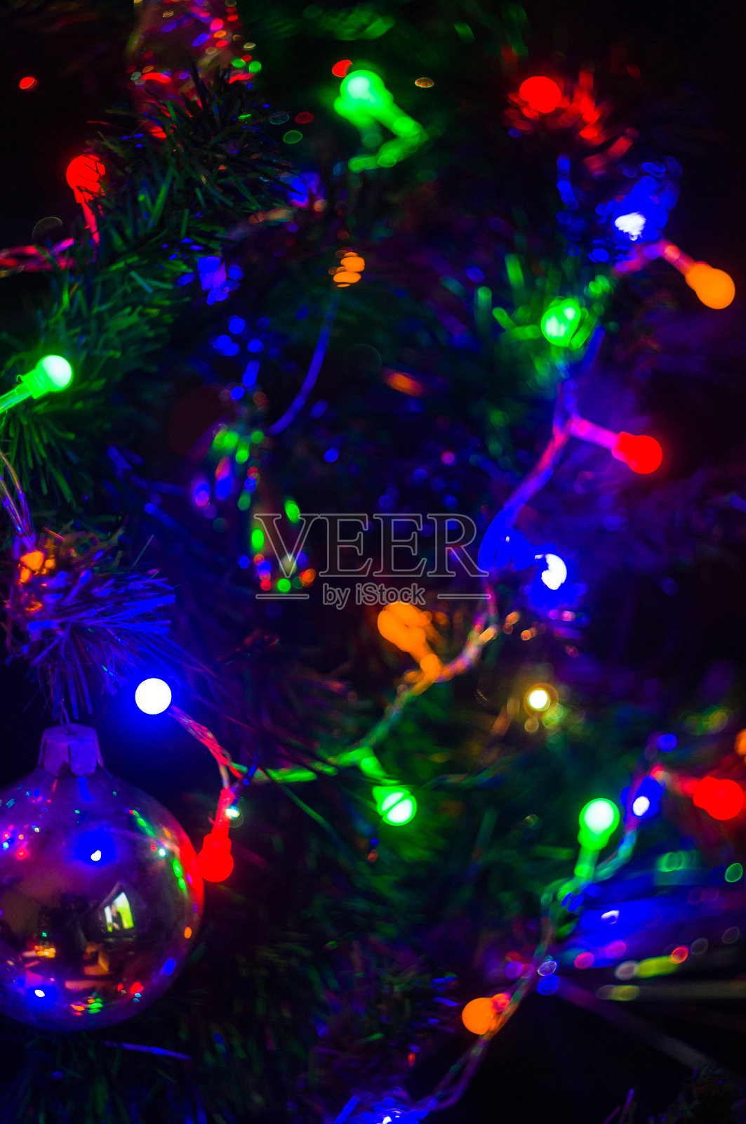 圣诞背景花环用五颜六色的彩灯装饰在圣诞树上，散焦，模糊照片摄影图片